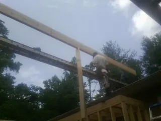 Carpenter setting a ridge beam over a new addition frame — Ice Dam Removal by Roofing Brothers in Cawood