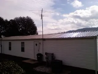 New metal roof on a single wide mobile home with a TV antenna in Cawood