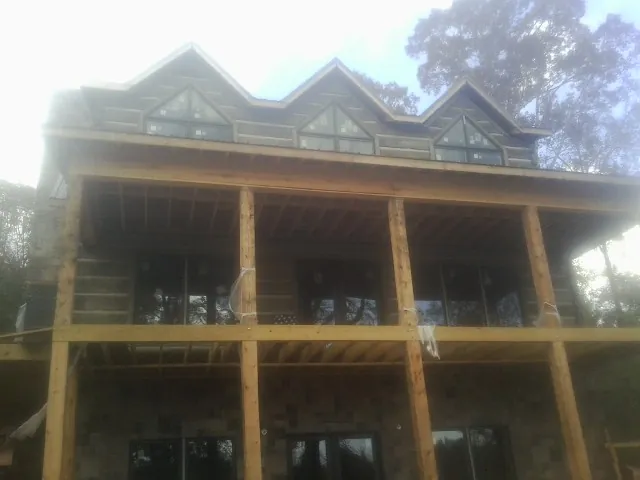 Dormers and porch framing on a large log home under construction — Roof Coating work by our crew in Cawood