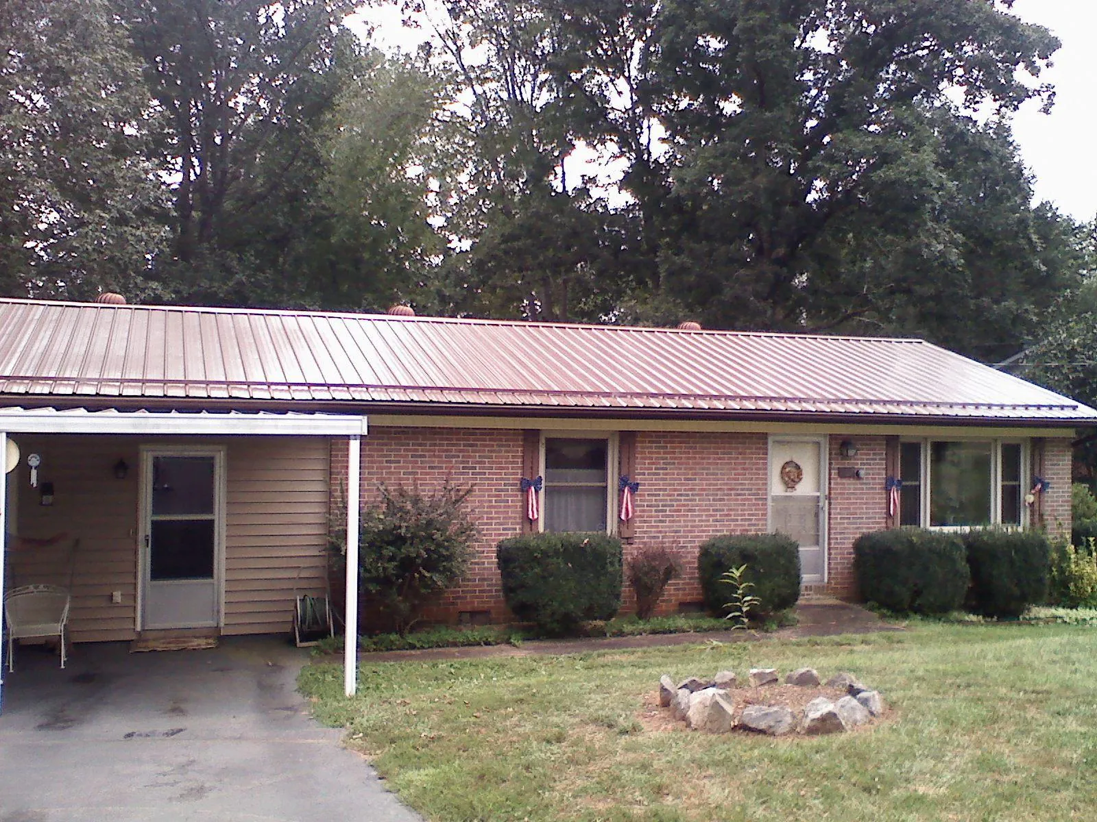 Bronze metal roof and carport on a brick ranch home — Roof Repair work by our crew in Cawood